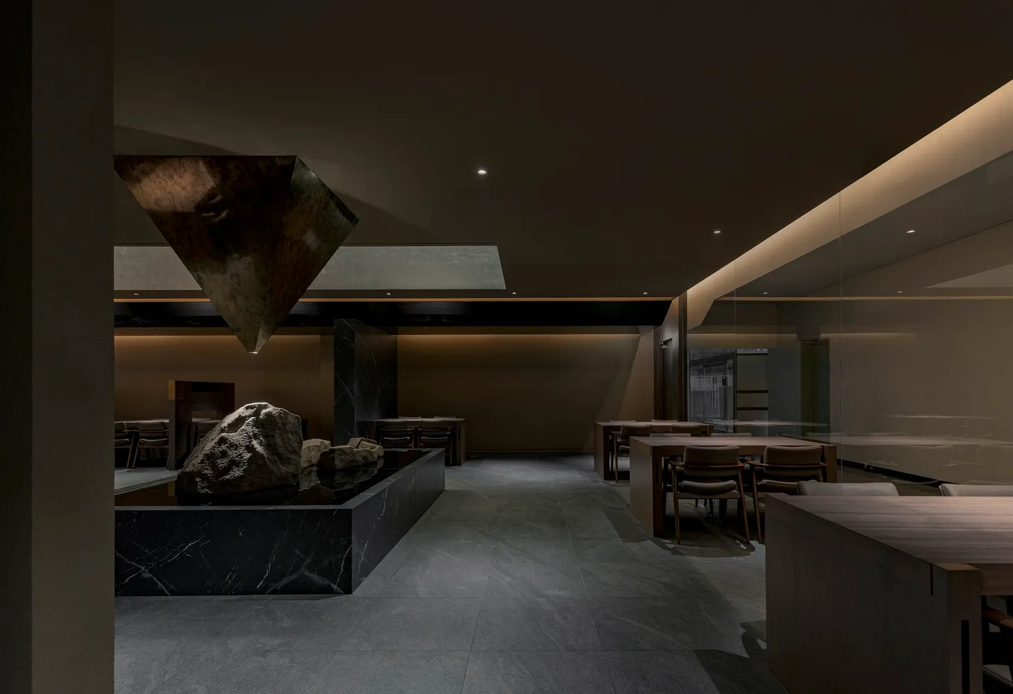 Interior design of a minimalist restaurant featuring marble surfaces and contemporary decor.