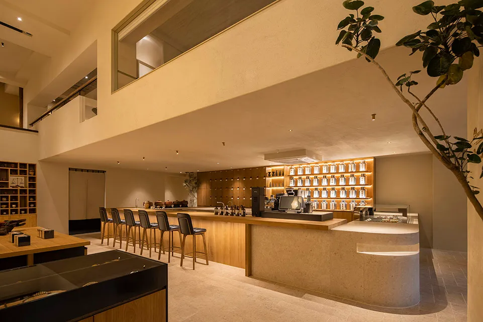 Interior of a modern minimalist coffee shop bar with wooden materials and a sleek design.