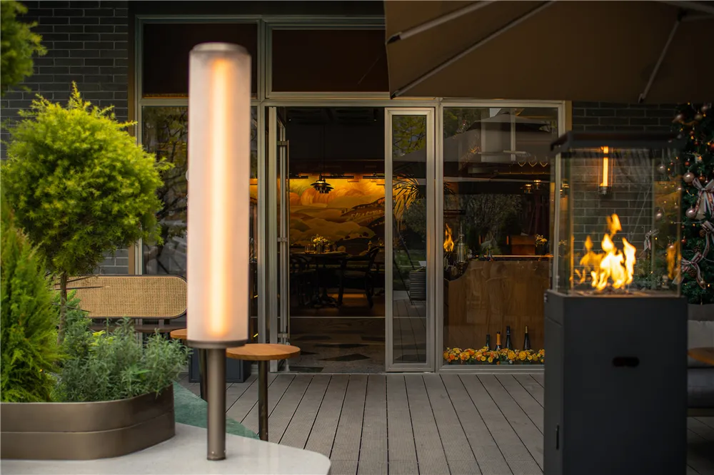A modern restaurant exterior showcasing glass panels, metal structures, and potted plants.