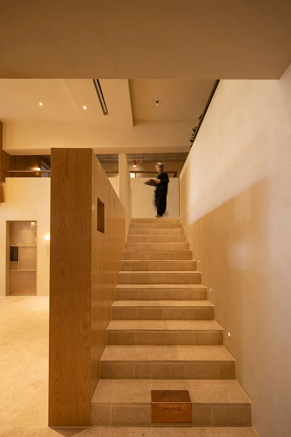 A modern stone staircase illuminated by ambient lighting within an elegant interior design setting.