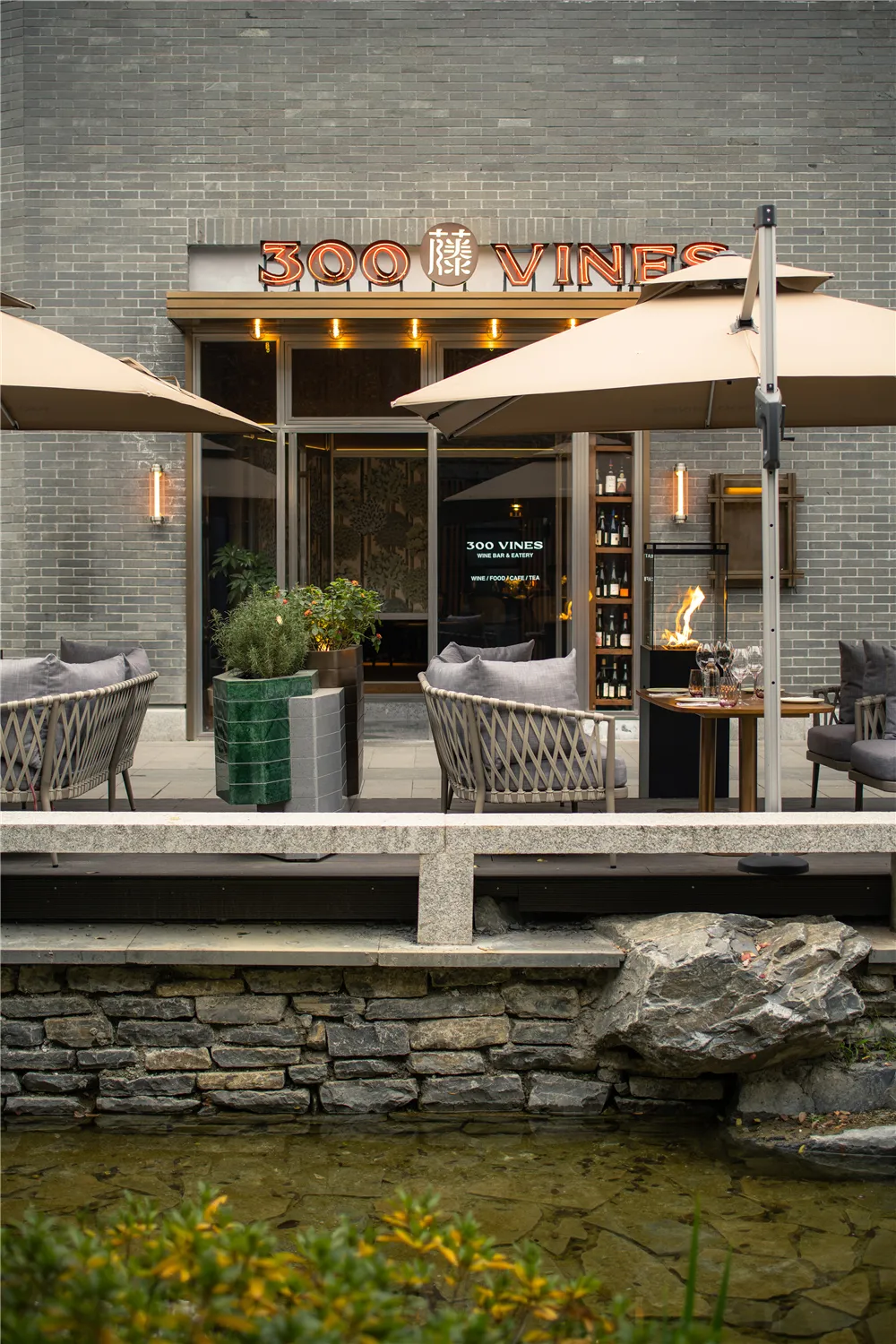 Modern restaurant exterior with brick, stone, and glass.