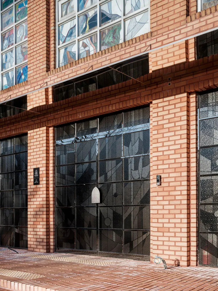 A modern brick facade with geometric stained glass windows.