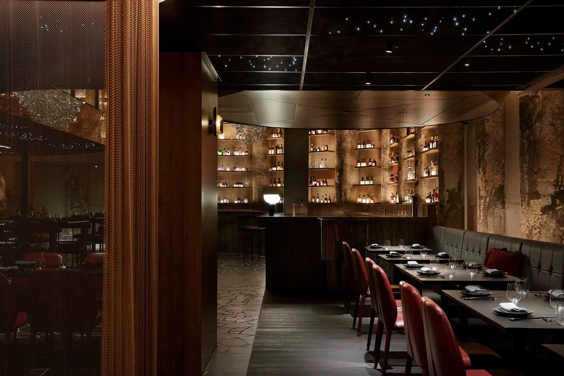 Interior design image of a modern restaurant featuring a textured concrete wall and brown leather seating