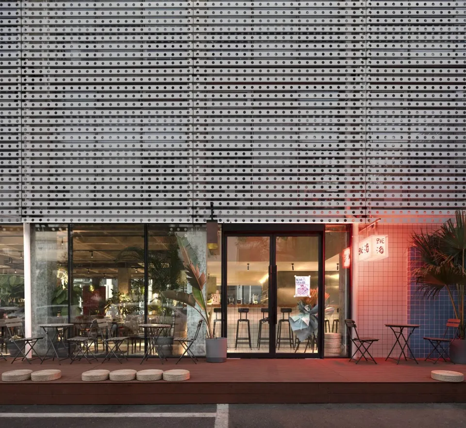 Modern restaurant exterior with a metallic facade and glass windows.