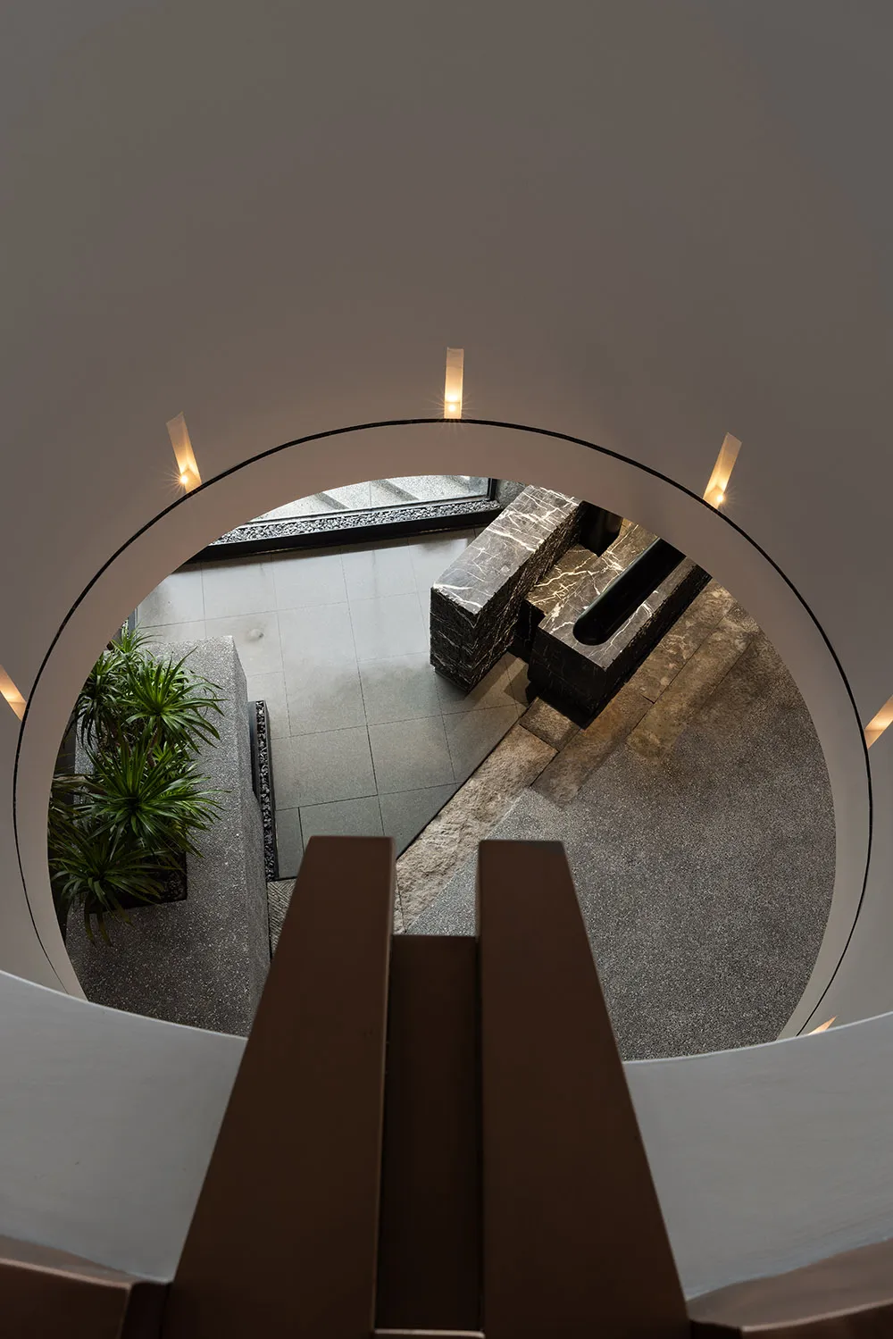 A modern living room featuring marble, concrete, and glass materials.