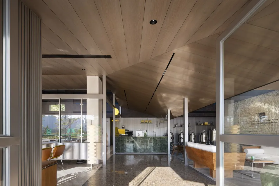 Minimalist design of a coffee shop interior featuring wood elements and industrial-style lighting.