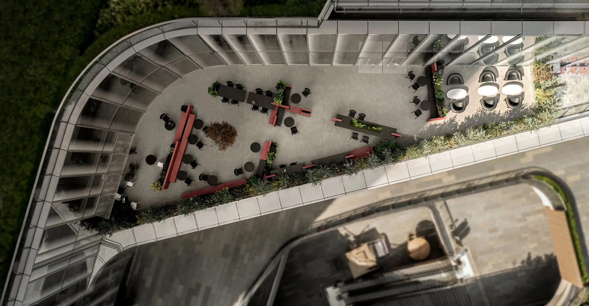 An aerial view of a modern office space with concrete flooring and terrazzo accents.