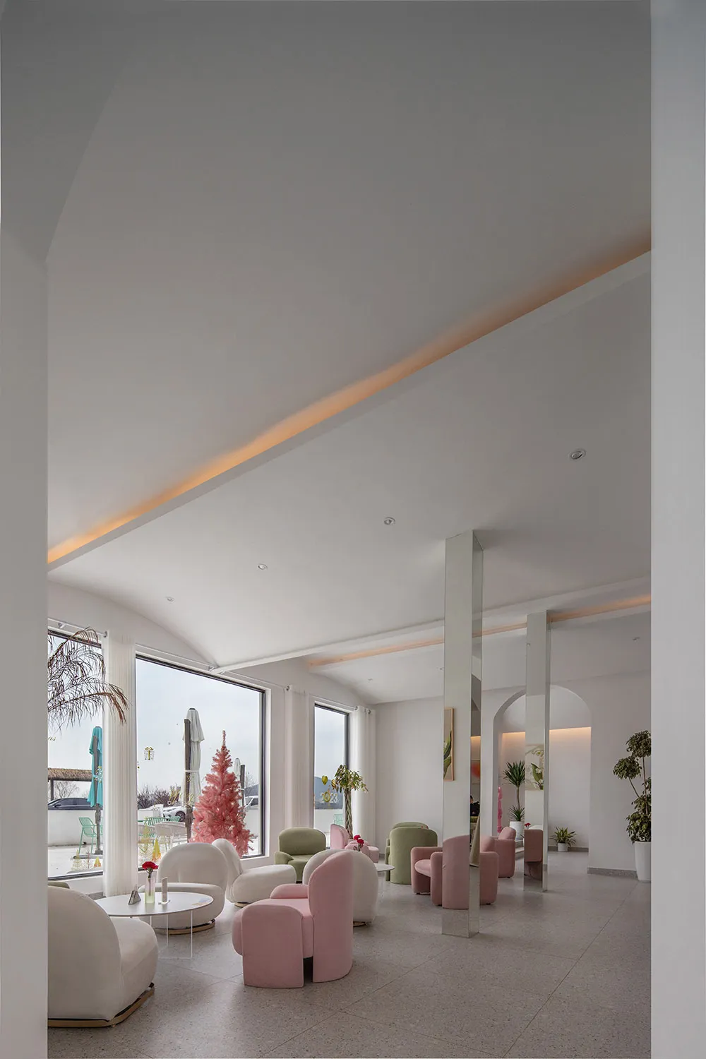 Modern hotel lobby featuring sleek, pink, and white furniture.