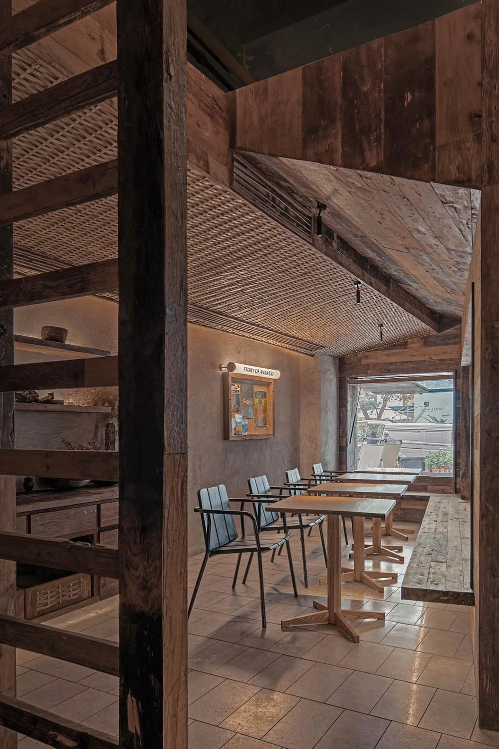 Industrial-style restaurant interior featuring wooden furniture and ceiling beams