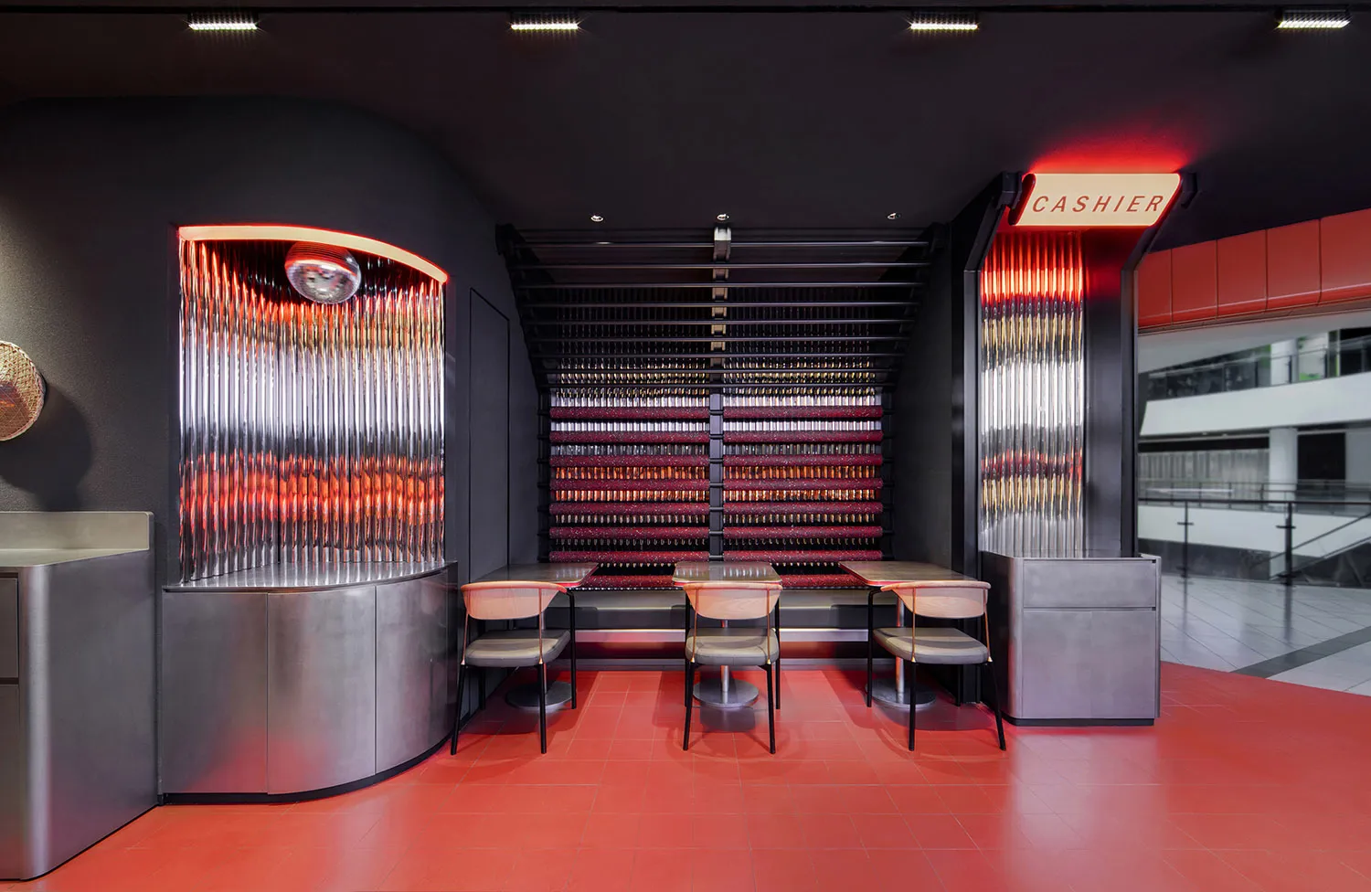 A modern, institutional cashier station with metallic tiles and strategic lighting.