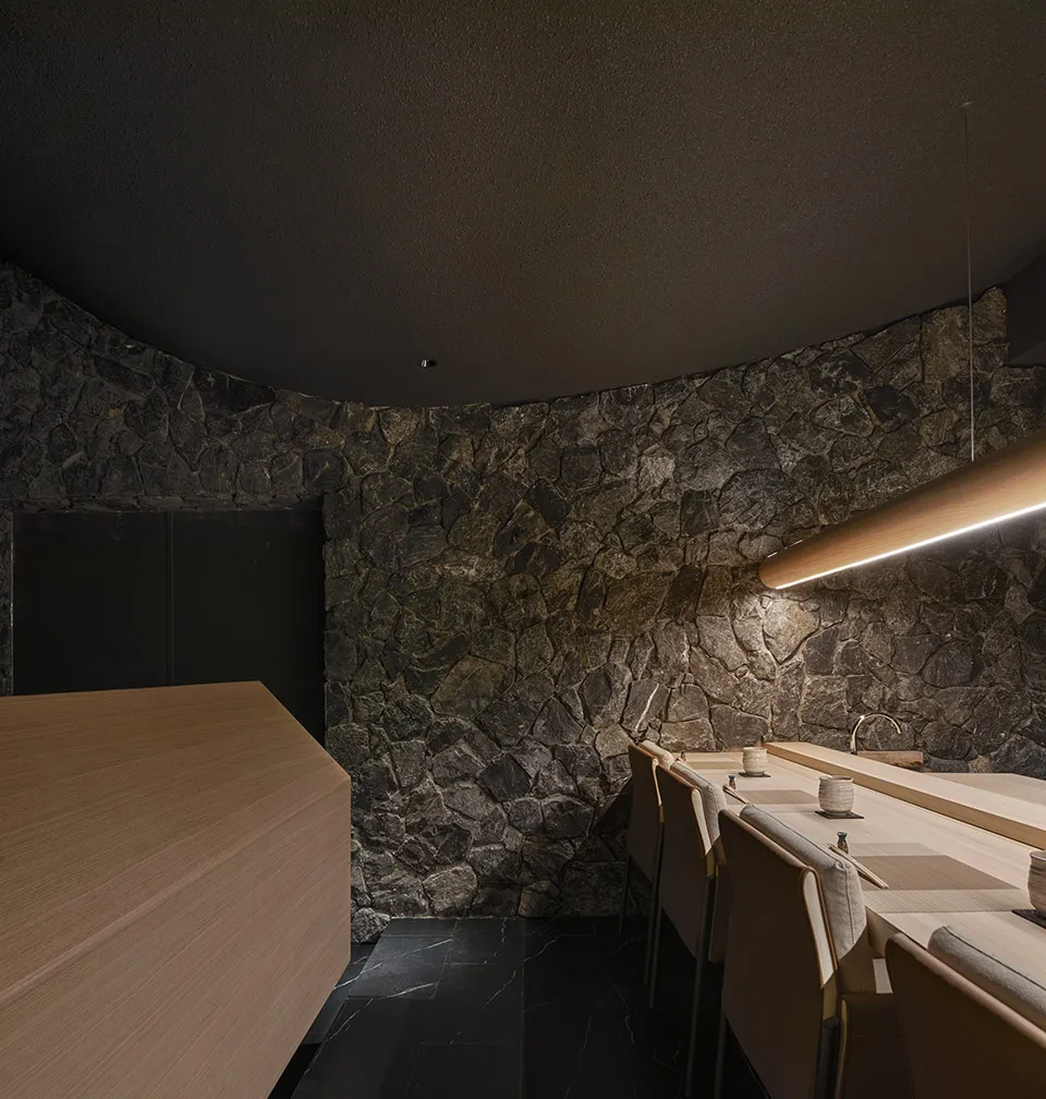 Modern restaurant interior with stone walls and wooden tables and chairs
