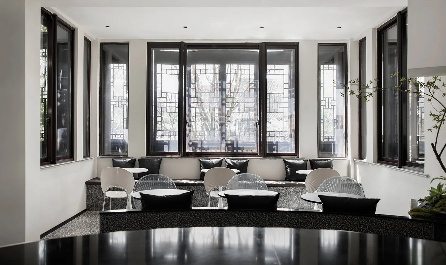 A modern cafeteria featuring glass walls, a concrete floor, and comfortable pillows