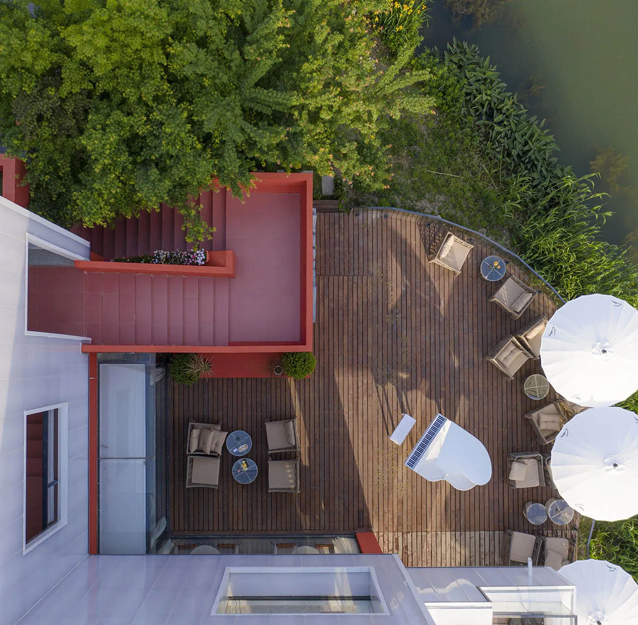 Modern residential patio with wooden flooring and outdoor furniture.
