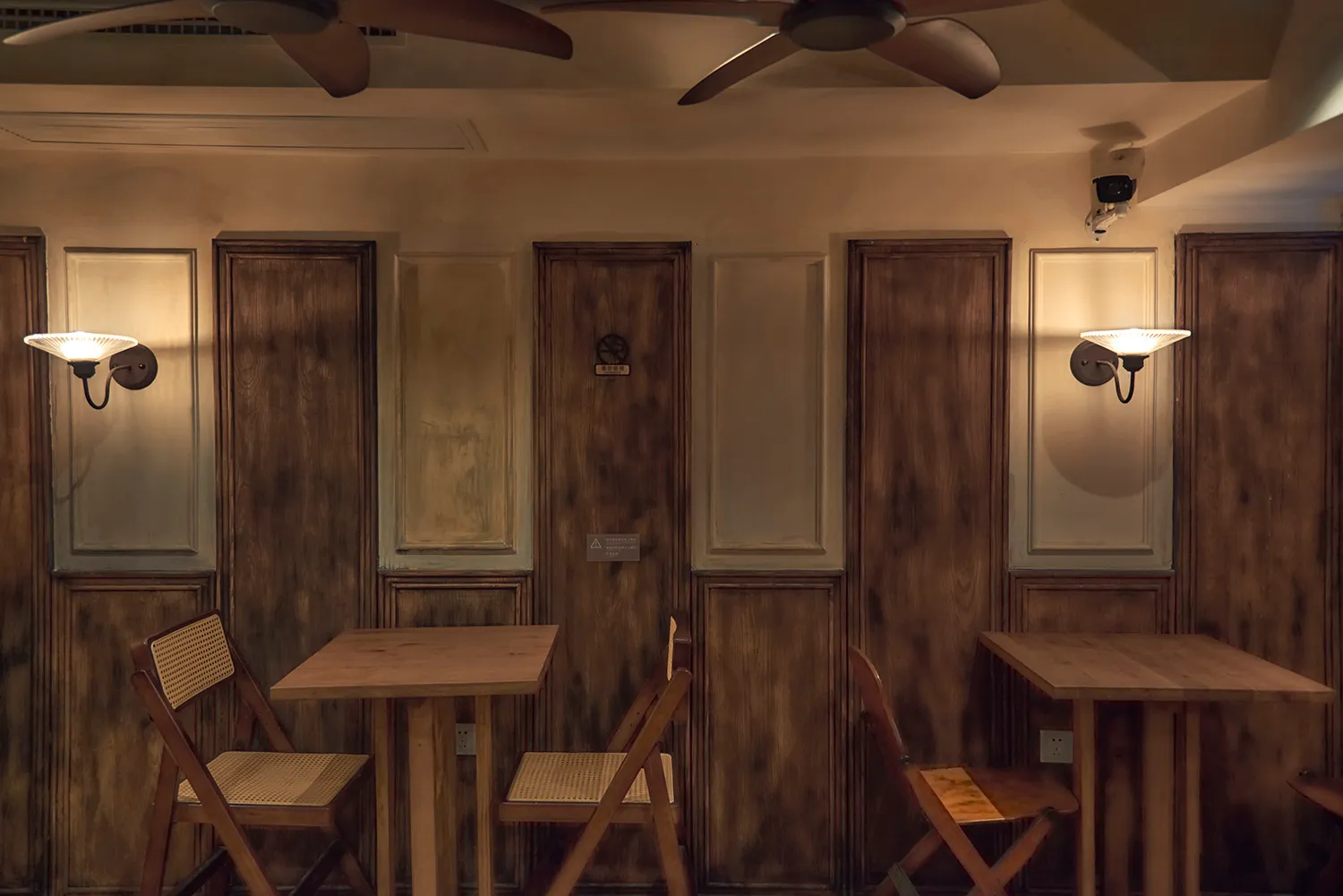 An industrial-style restaurant interior with wood paneling and tables.