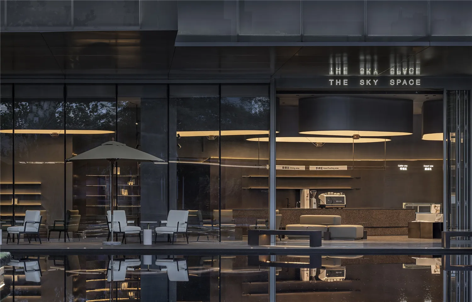 A modern coffee shop with sleek, minimalist interior design featuring contemporary furniture and lighting.