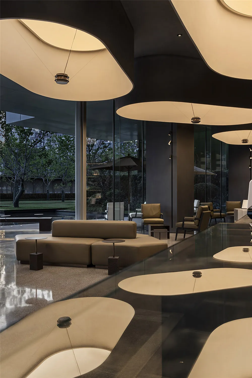 Modern hotel lobby with large glass walls and contemporary furniture.