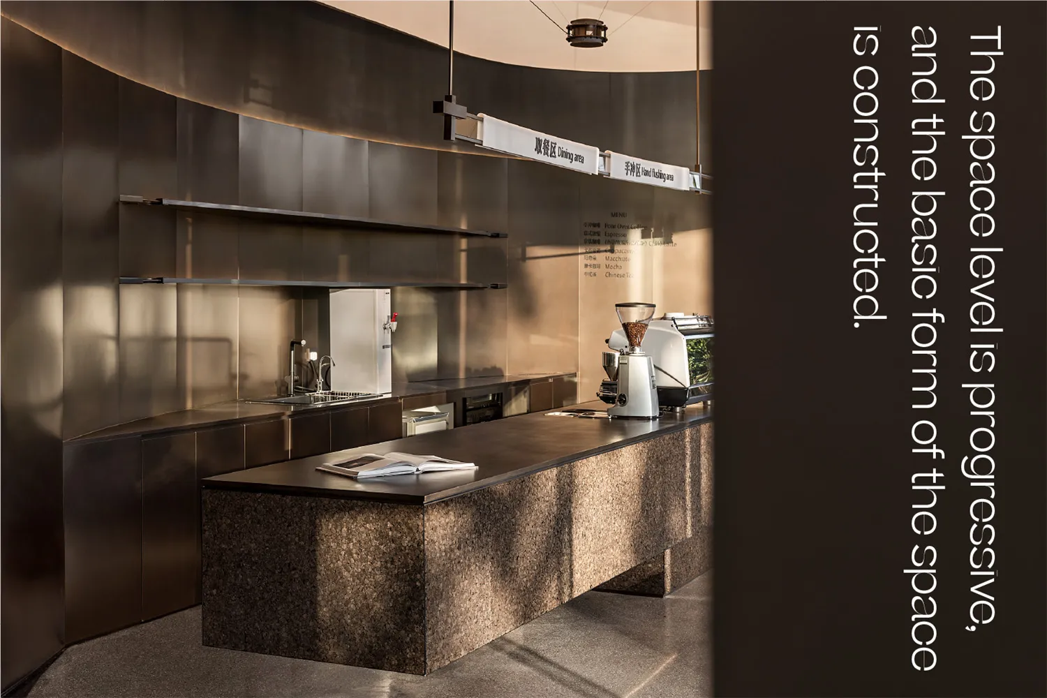 Modern industrial-style coffee shop with a sleek metal countertop and stone base.