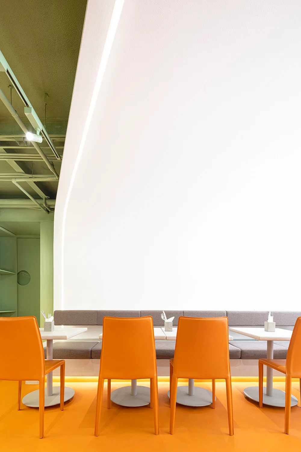 Modern restaurant cafe seating area with orange leather chairs and metal legs