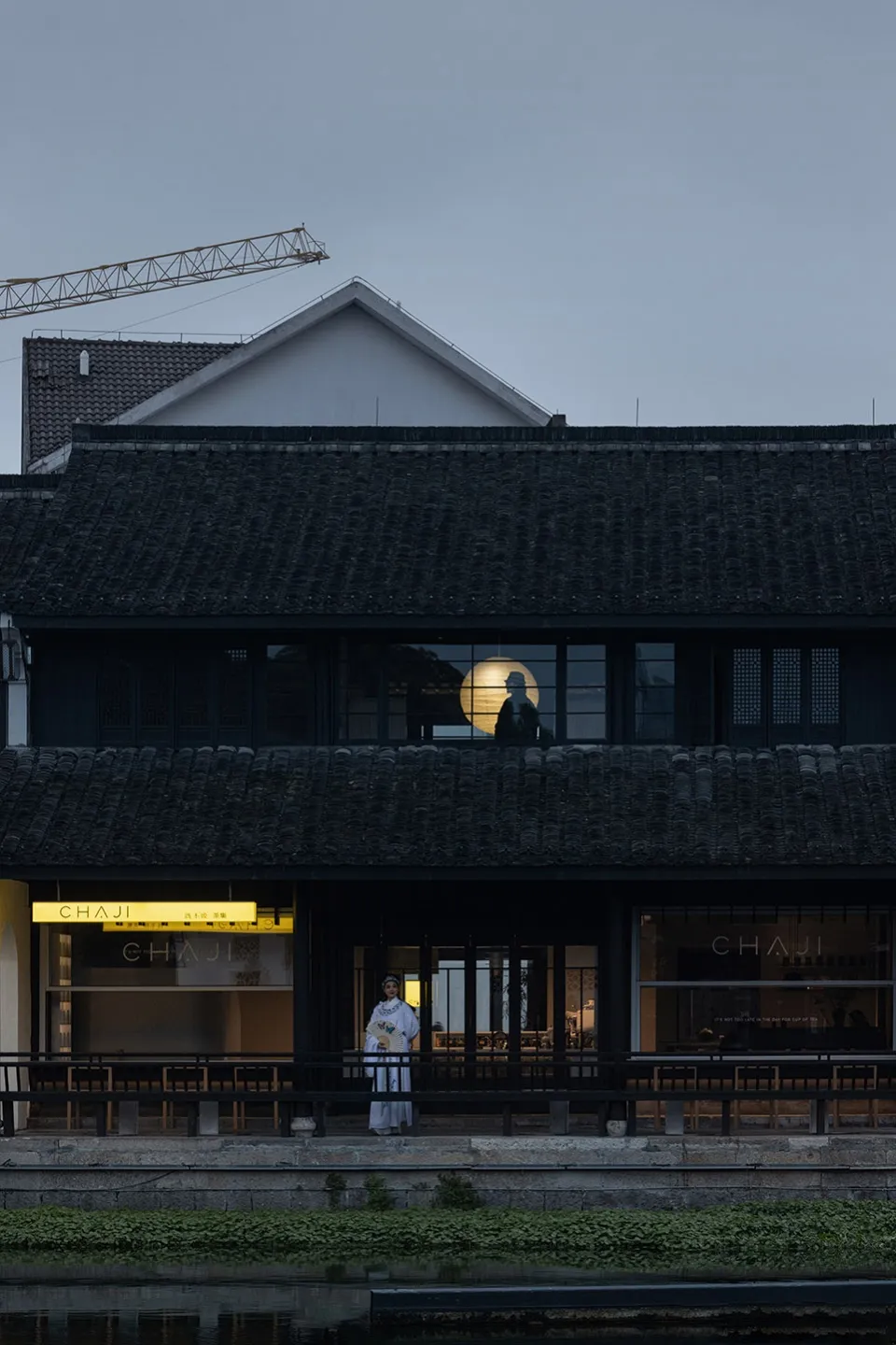 傳統零售店面，磚牆搭配瓦片屋頂，入口前站著一位人物。