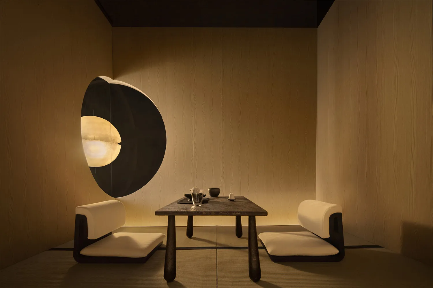 A minimalist restaurant interior featuring a wooden table with tea service, soft lighting, and white seating on tatami mats.