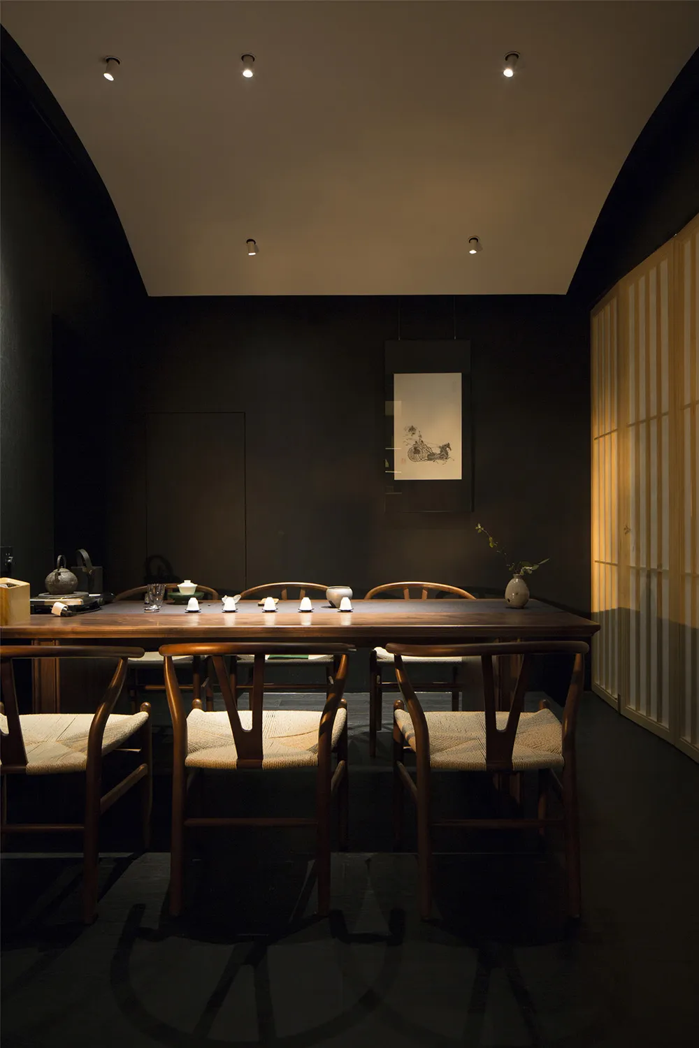 A modern dining room featuring wooden furniture and artistic wall decor.