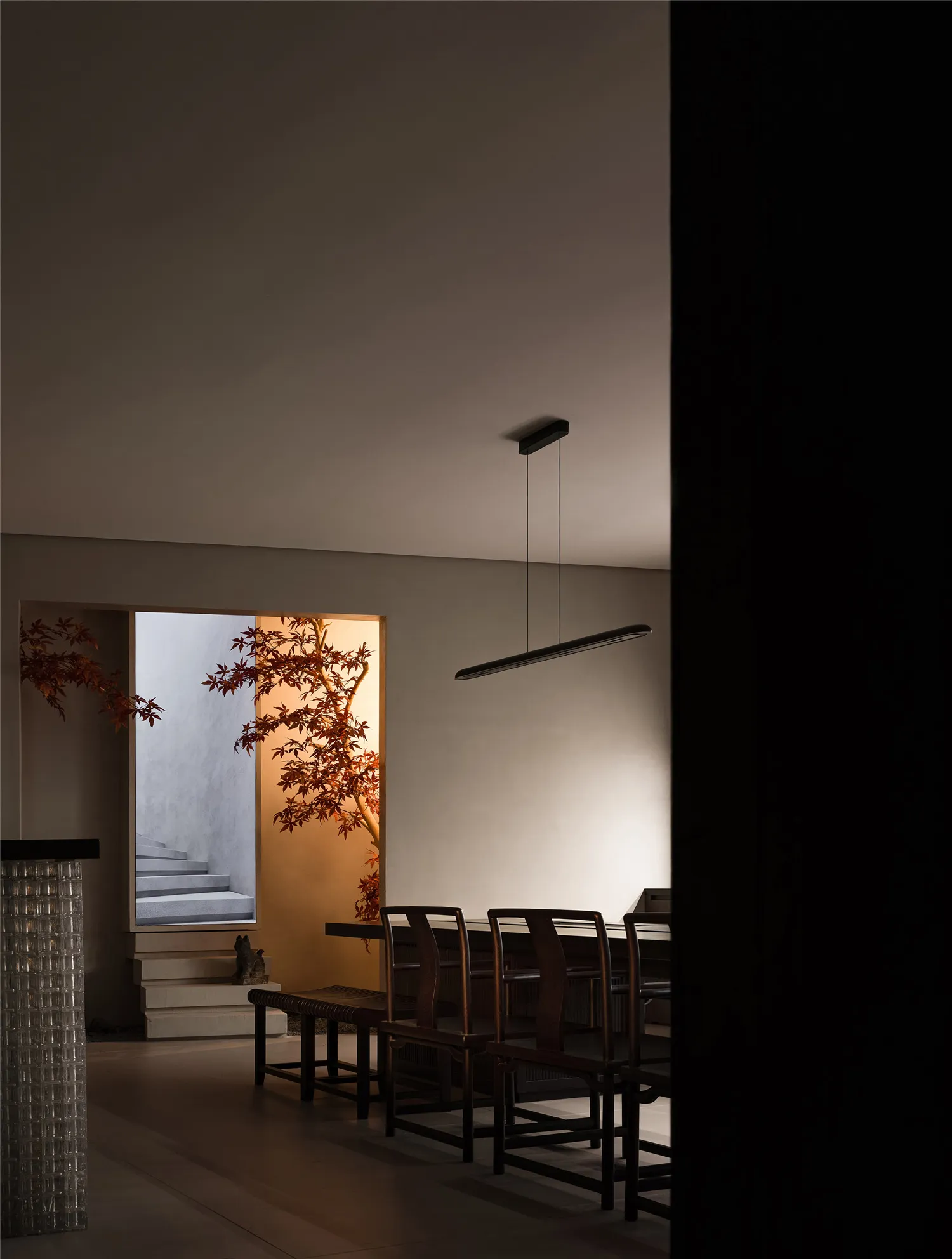 A minimalist interior design featuring wooden furniture and warm lighting.