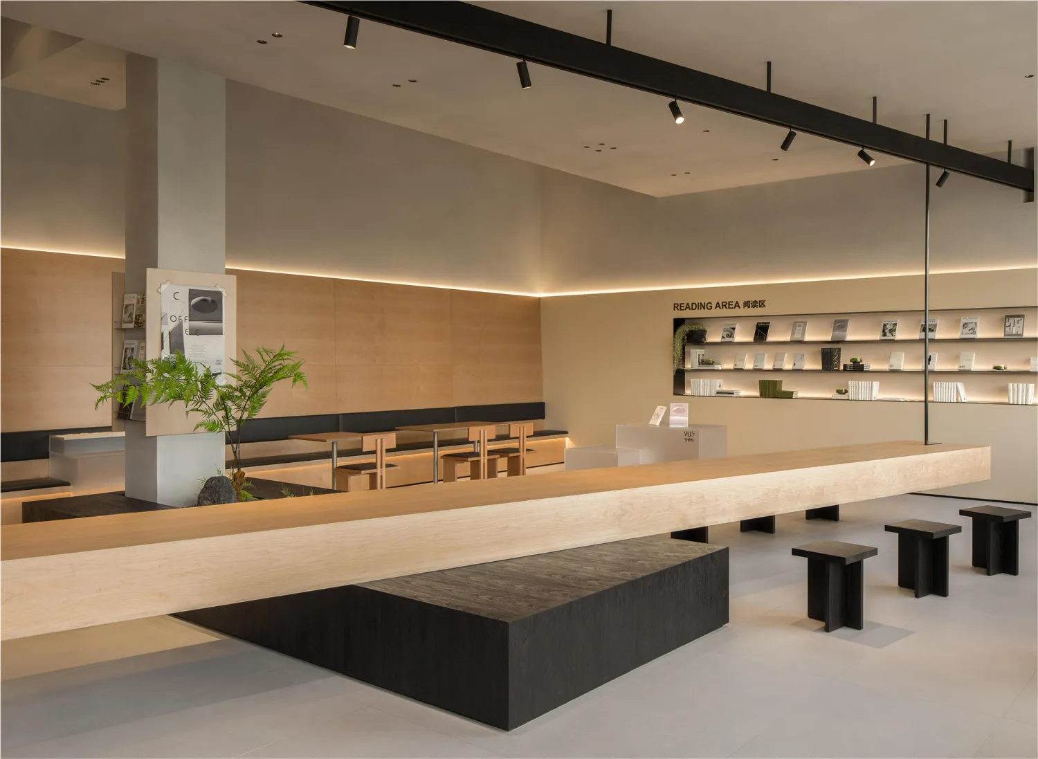 Modern coffee shop interior with wooden tables, concrete accents, and a minimalist design.