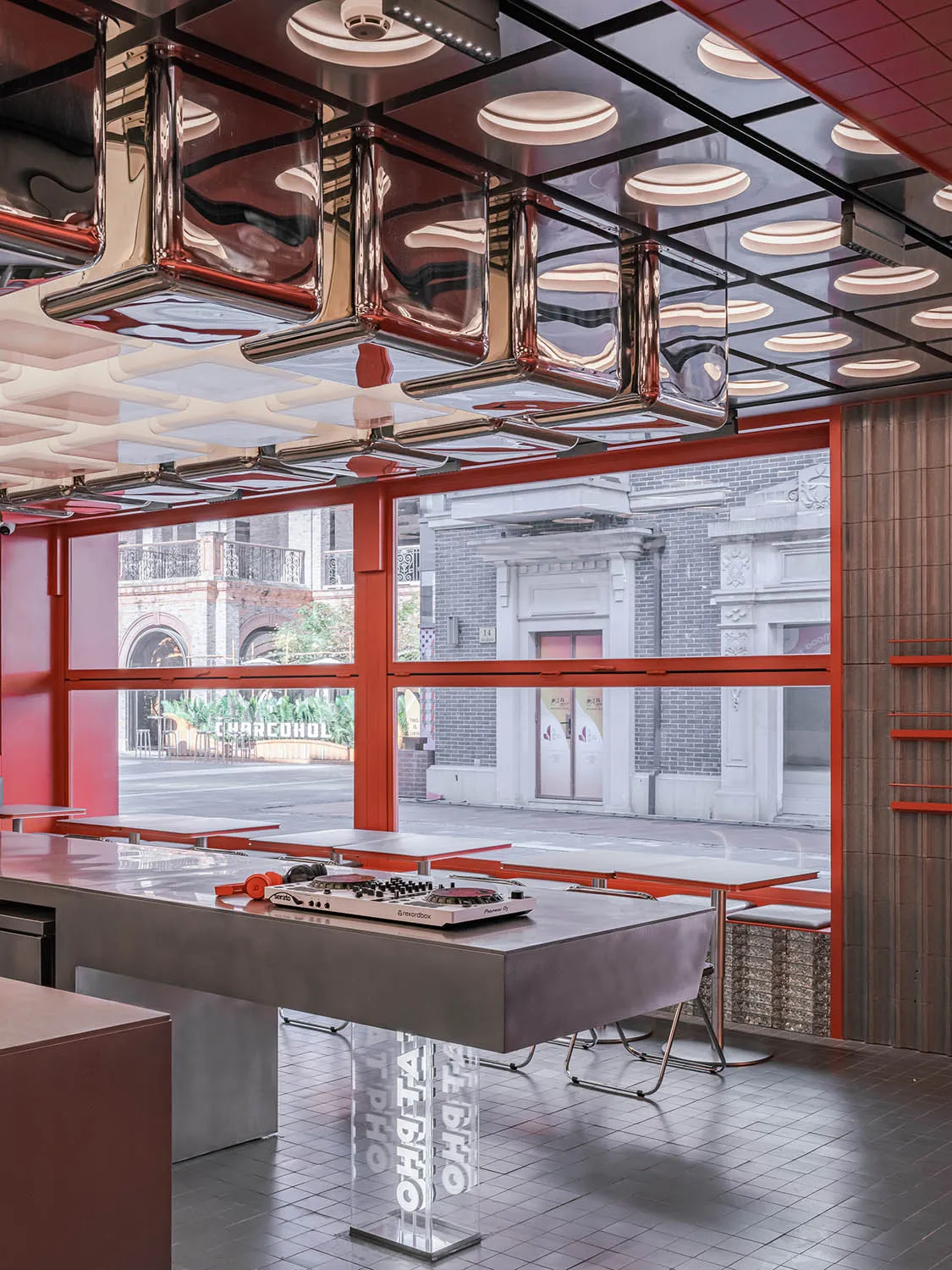 Contemporary restaurant interior featuring a modern, industrial metal counter with stools.