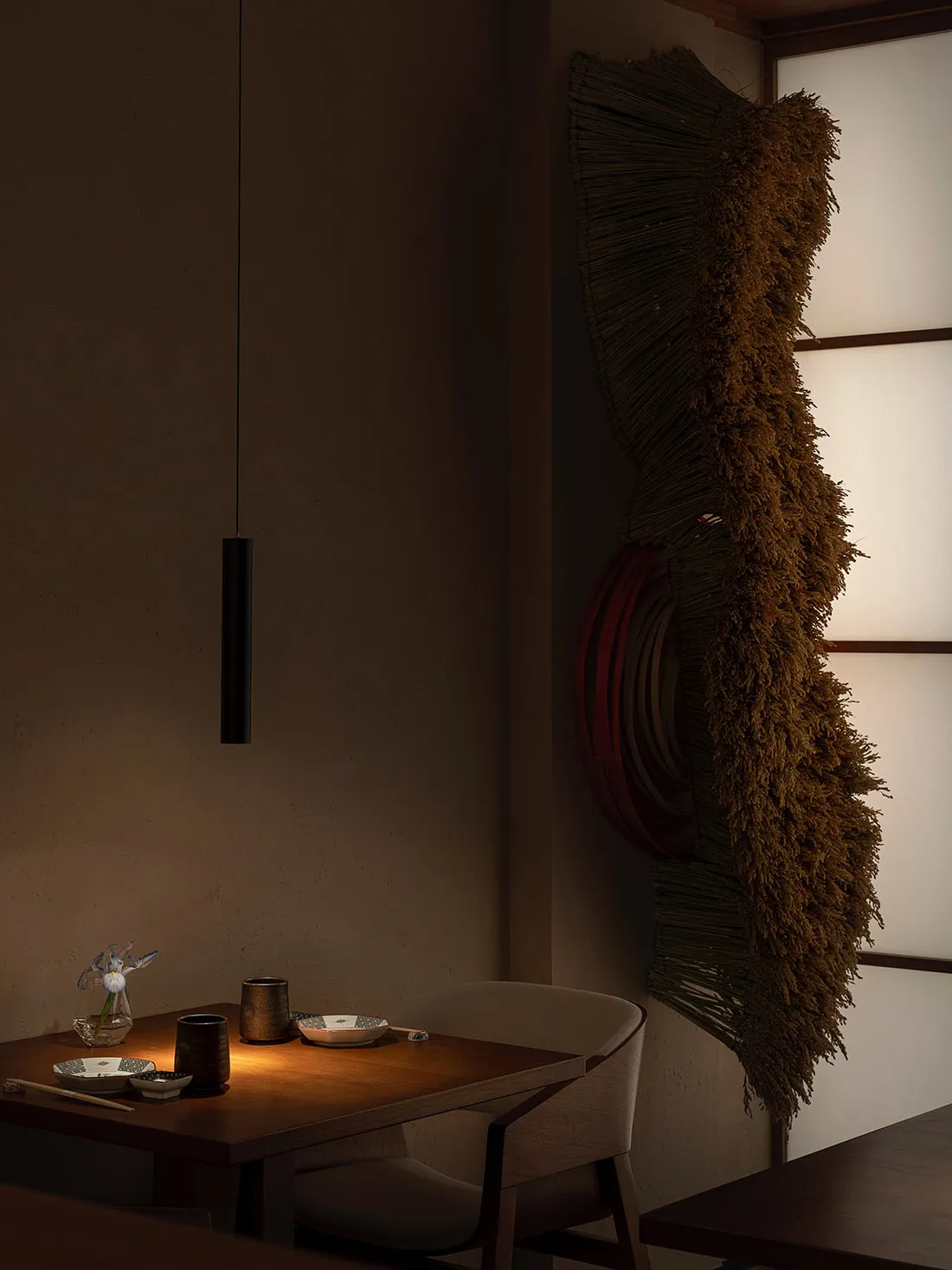 A minimalist dining room with wooden furniture and fabric wall hanging.
