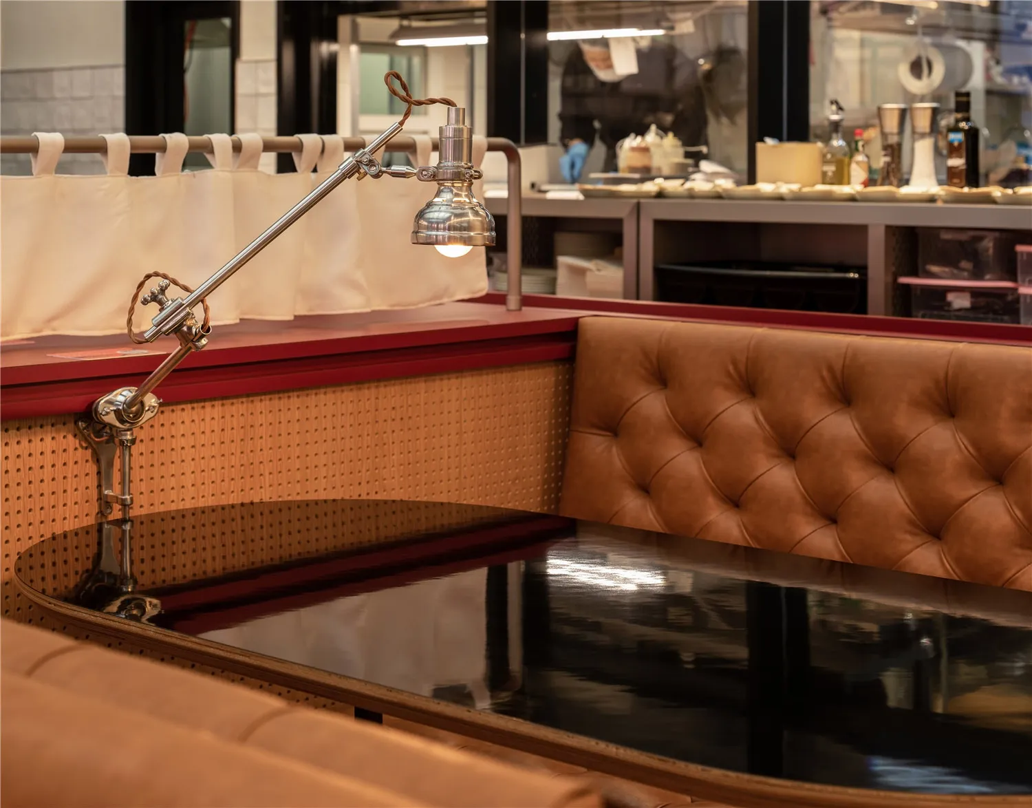 A restaurant booth with a metal lamp and brown leather upholstery