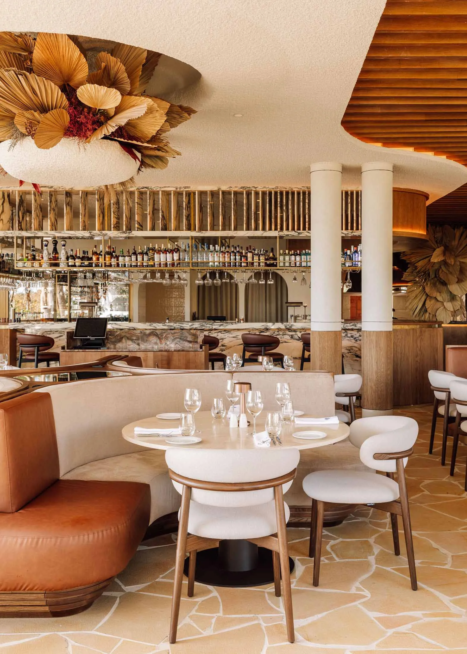 Modern restaurant bar with concrete floor, wood accents, and marble finishes