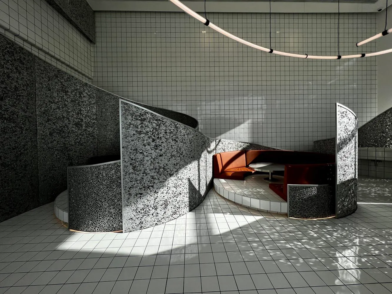 Modern interior design space featuring concrete walls and mosaic tile seating