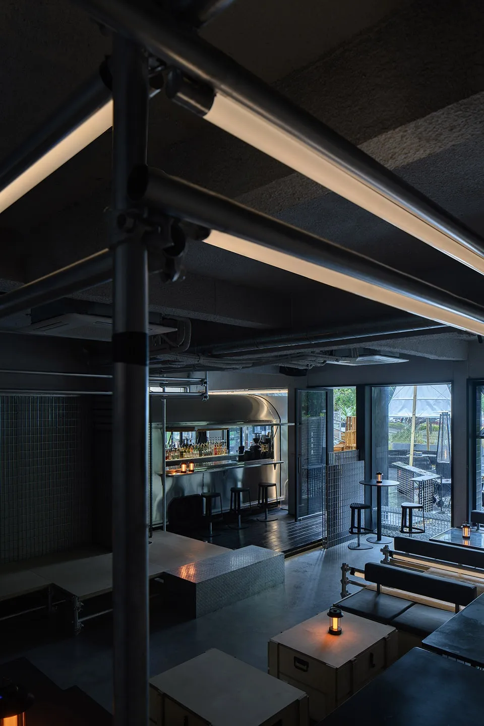 金屬工業風餐廳酒吧室內,裸露管線與混凝土地板。