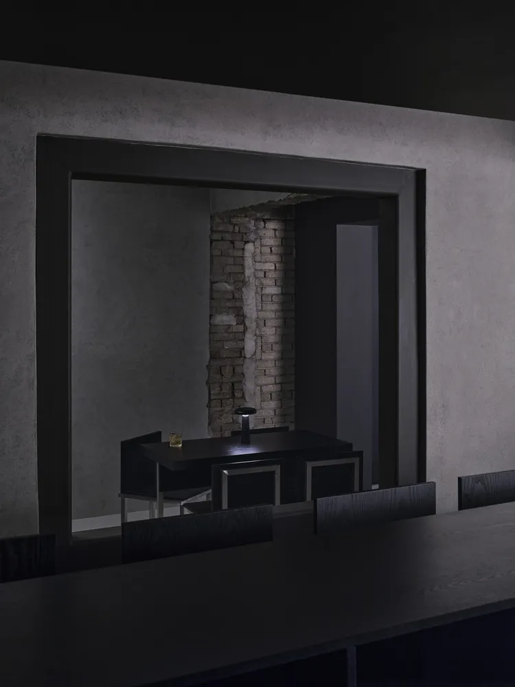 A minimalist black interior with exposed brick wall