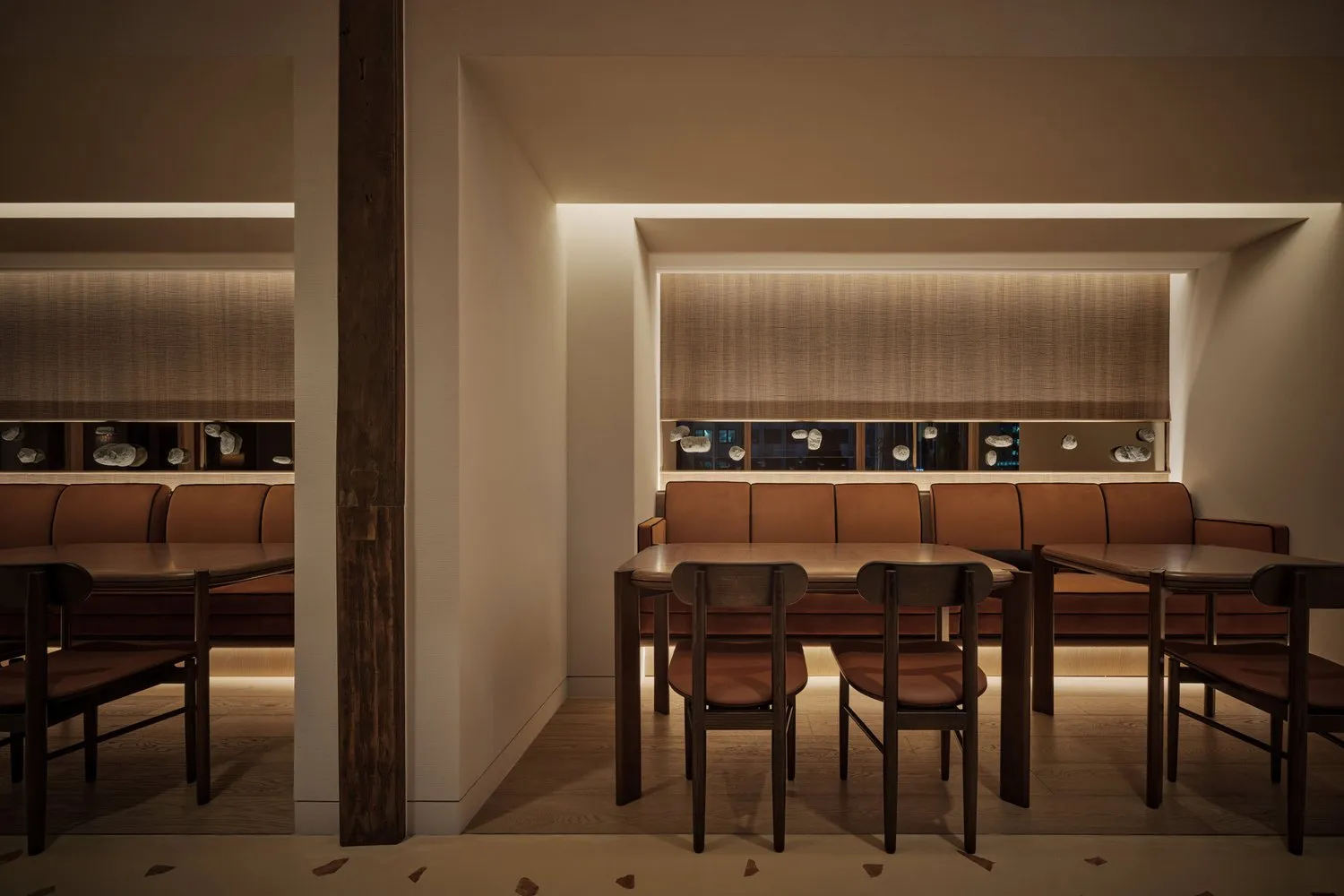Modern interior design of a restaurant featuring brown leather seating and wooden tables.