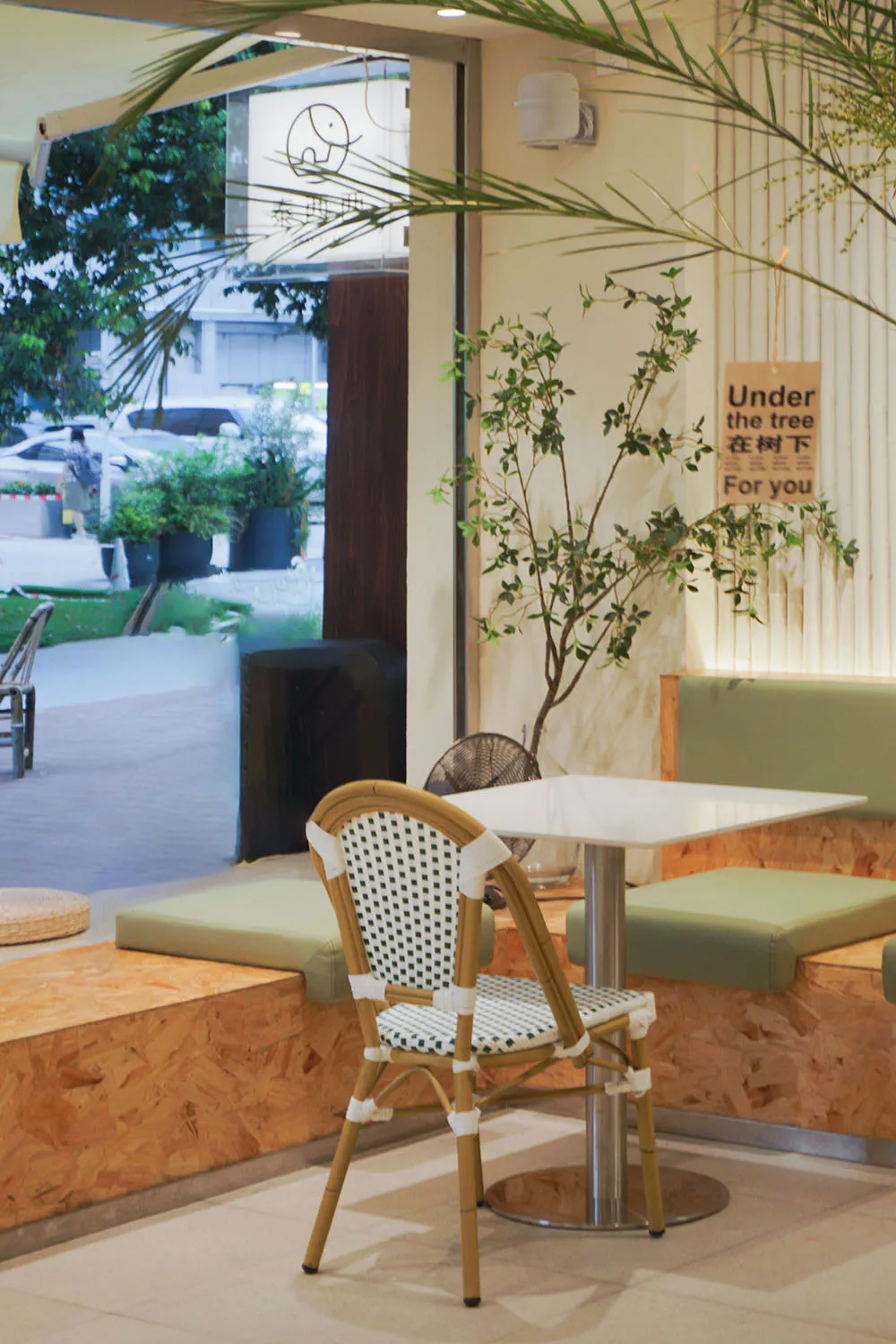 A cozy cafe interior featuring wooden seating and white plaster walls.