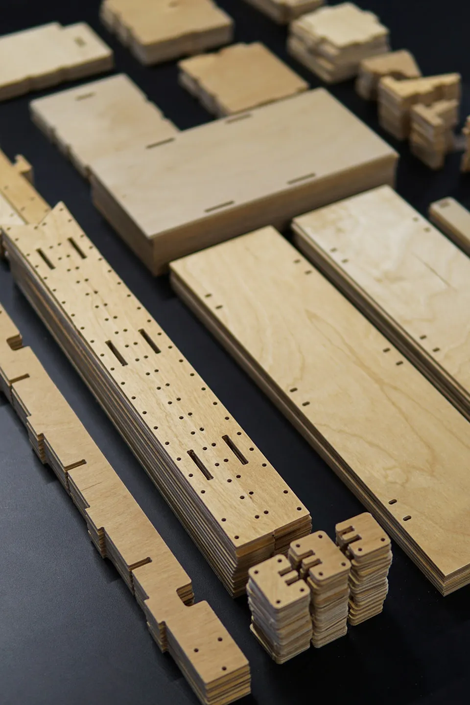 Stacked layers of plywood with cutting patterns for furniture assembly
