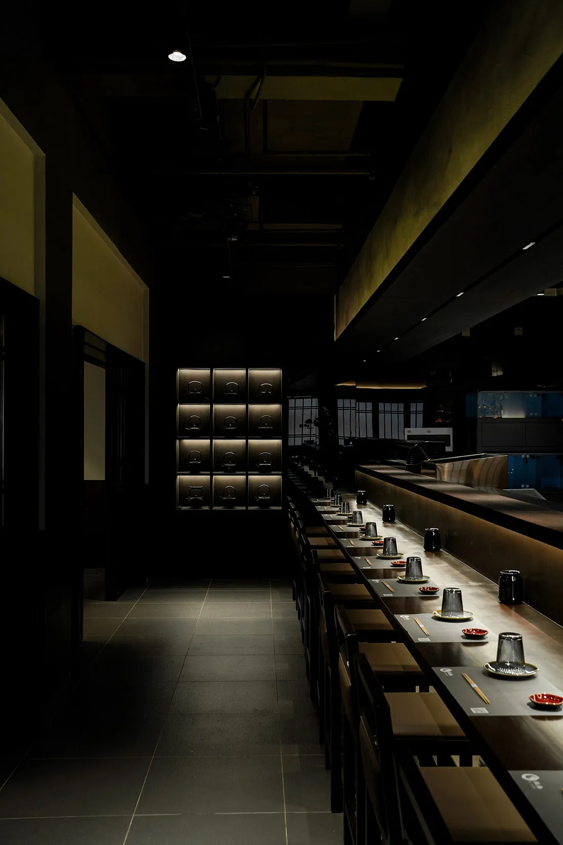 Modern Japanese restaurant featuring dark wood and black laminate seating area and counter