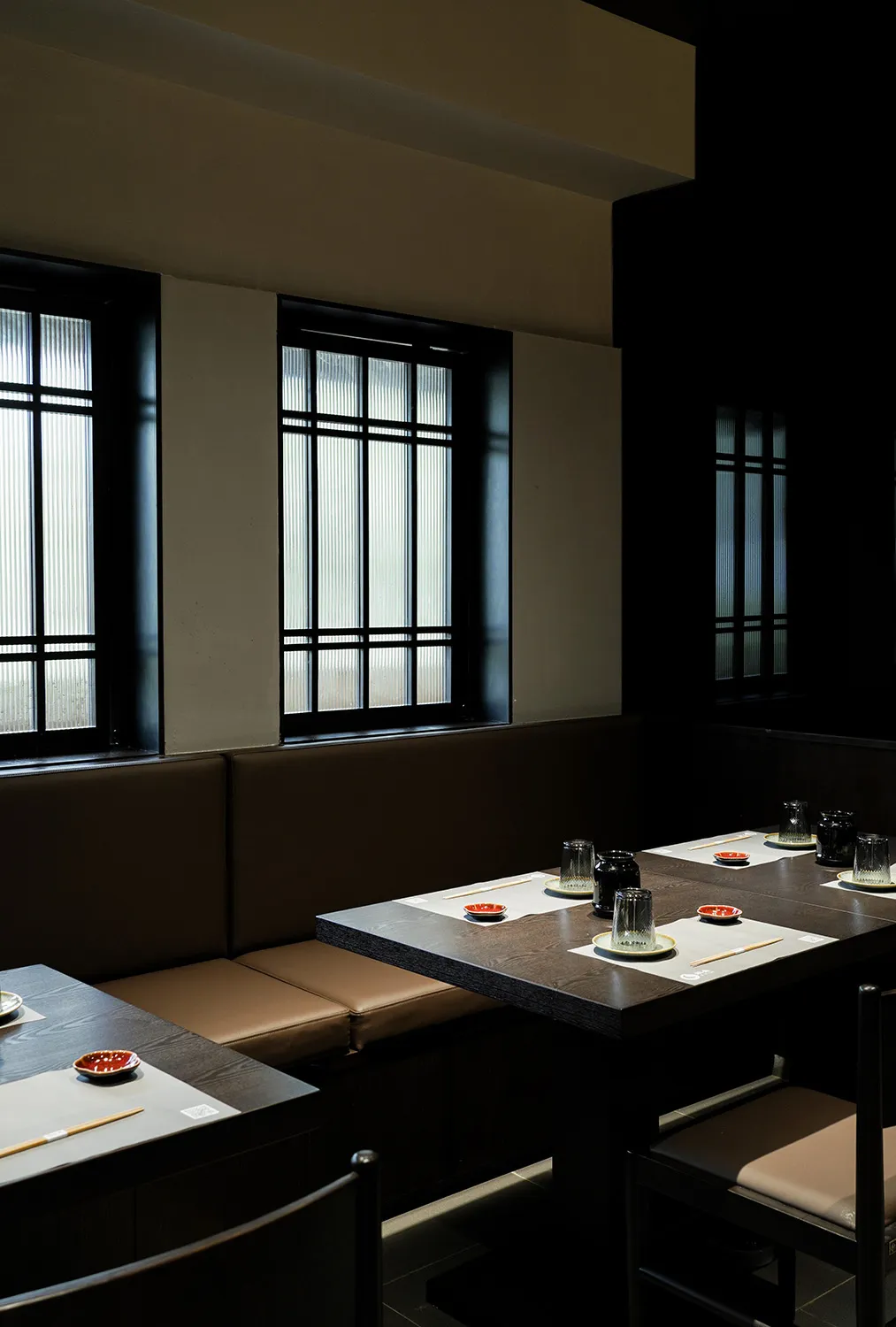 Modern restaurant interior featuring wooden tables and seating arrangements.