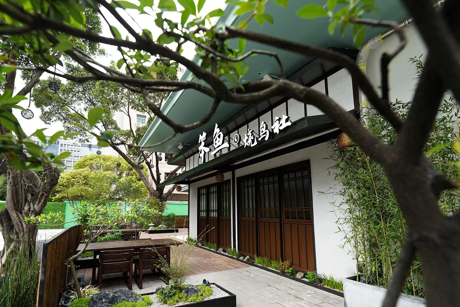 Outdoor seating area with wooden tables and chairs at a Japanese restaurant.
