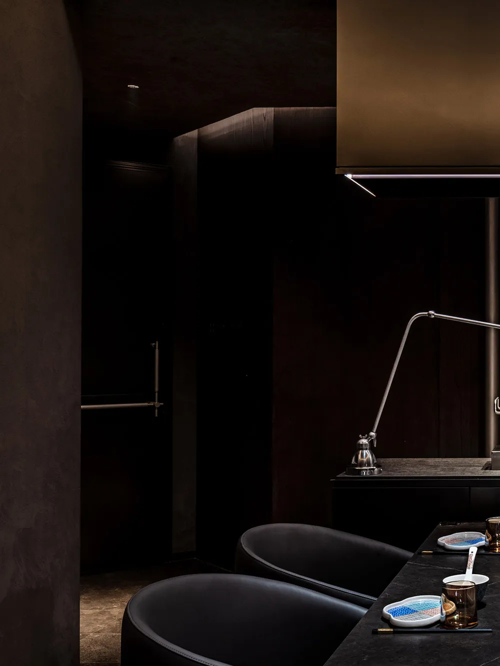 A modern restaurant interior with black furniture, metallic accents, and a sleek design.