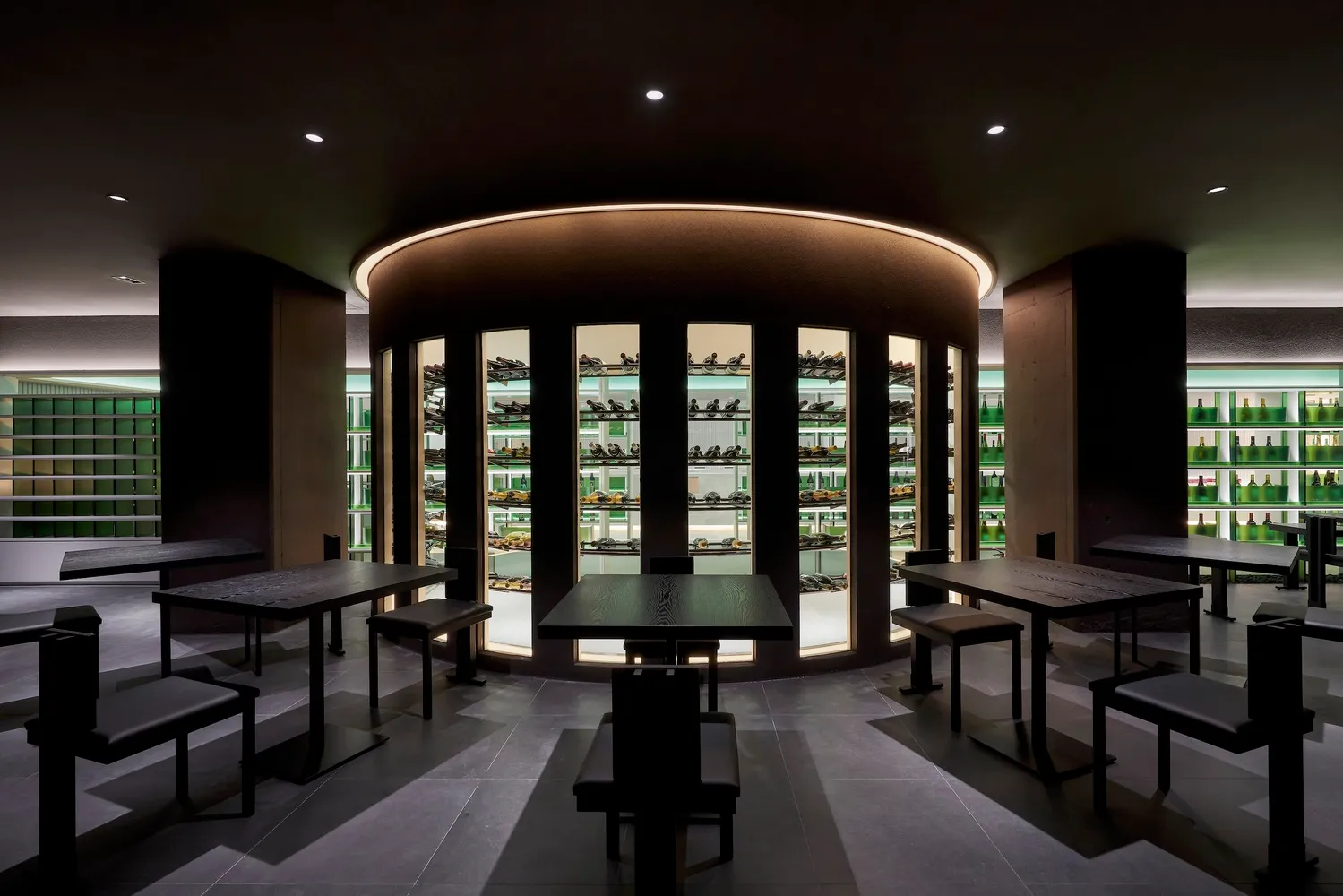 Modern minimalist restaurant interior featuring black tables and a sleek, minimalist design with steel and glass materials.