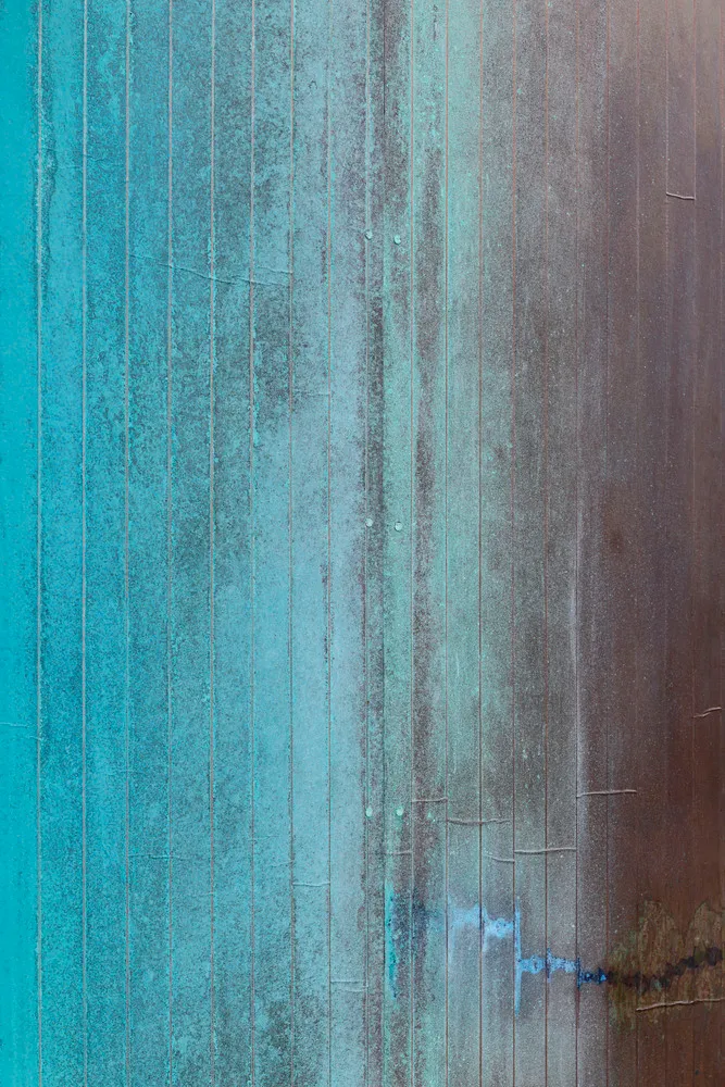 Vertical striped wood panel with a blue-green and brown coloration, showing signs of wear and tear.