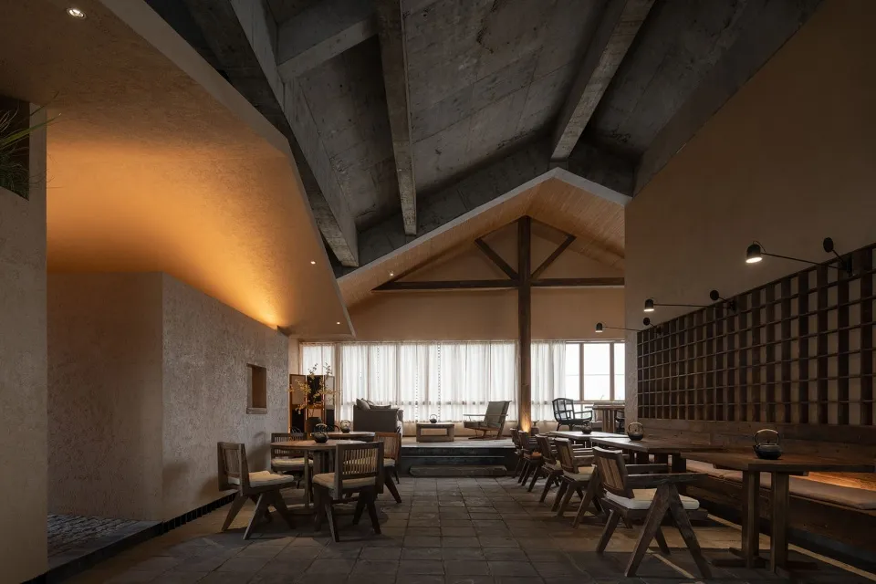 工業風餐廳室內,裸露混凝土牆面與天花板橫樑。