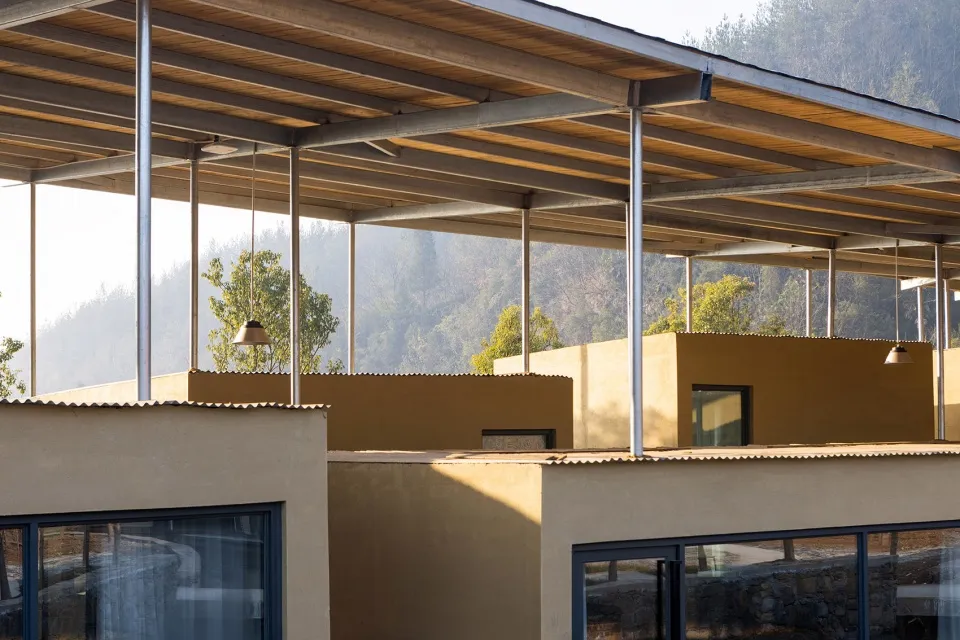 A modern residential architecture featuring a concrete exterior with large open spaces and structural beams.