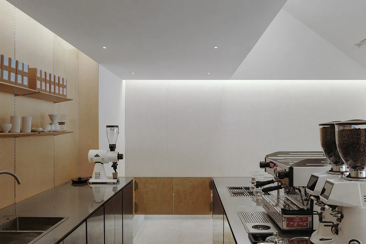 A minimalist coffee shop interior featuring wood materials and modern design elements.