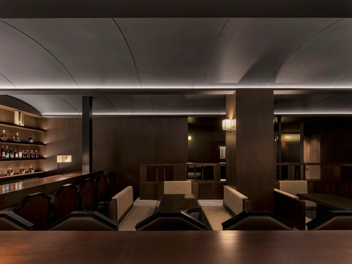 A modern restaurant bar with dark wood and high gloss surfaces.