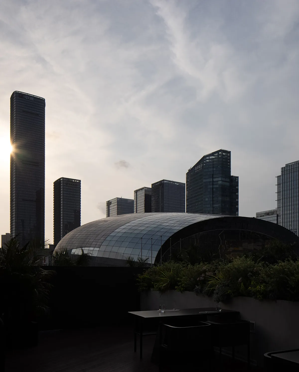 一座玻璃覆面的建築物在城市景觀背景下顯眼矗立。