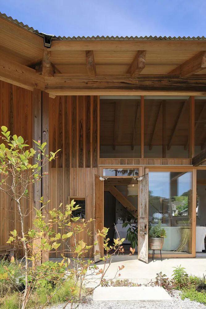 現代工業風房屋外觀，木質牆面搭配波浪金屬屋頂。