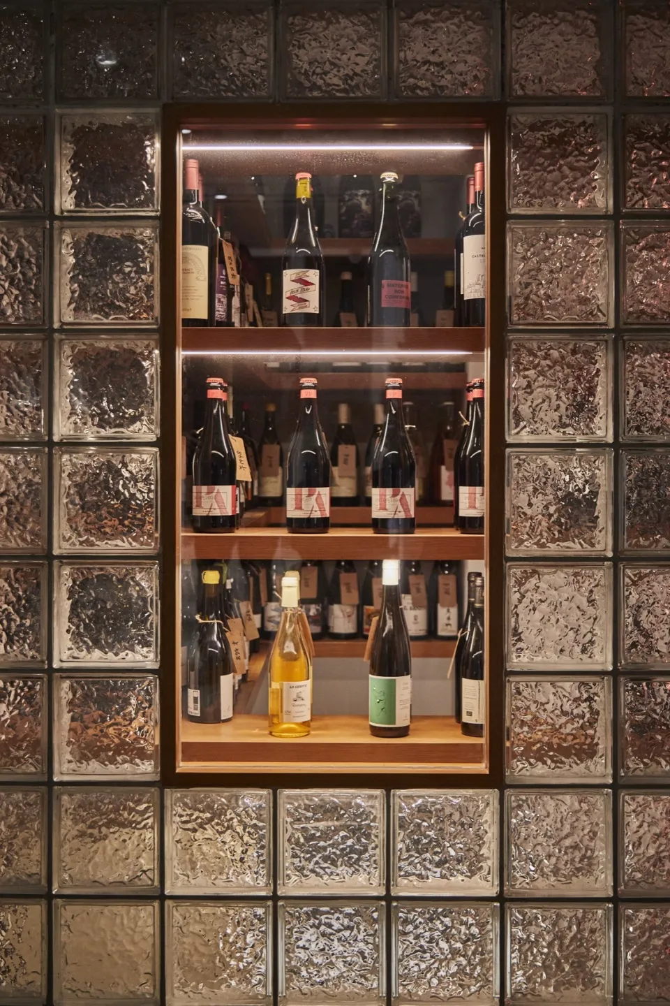 A wine bar display featuring glass blocks with bottles of wine arranged on shelves.